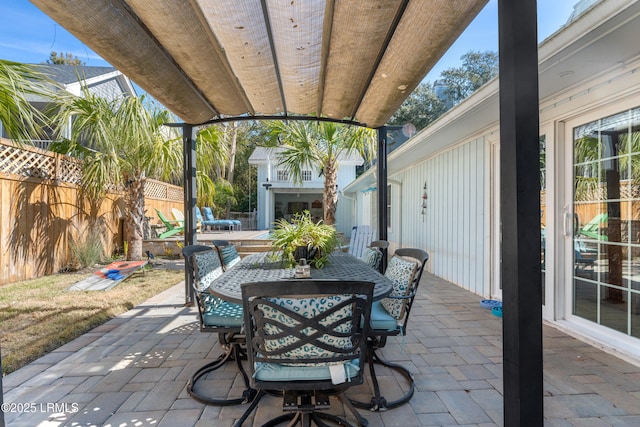 view of patio featuring outdoor dining area and fence