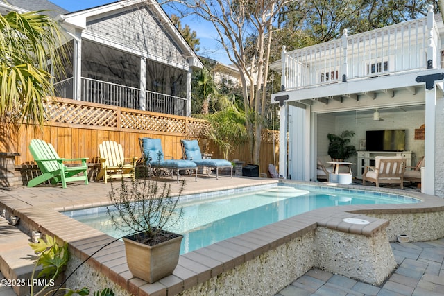 view of swimming pool featuring a fenced in pool, a sunroom, a patio area, and fence