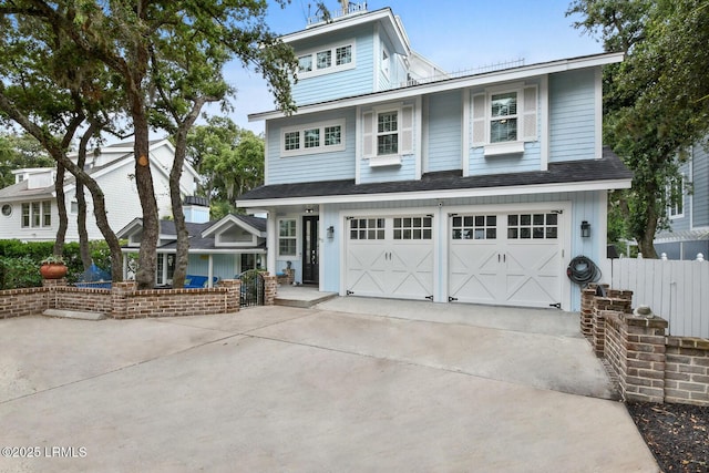 view of front of house with driveway, a shingled roof, a garage, and fence