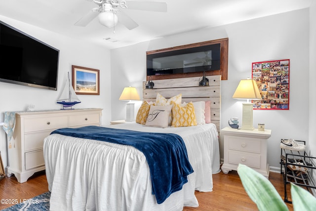 bedroom featuring visible vents, wood finished floors, a ceiling fan, and baseboards