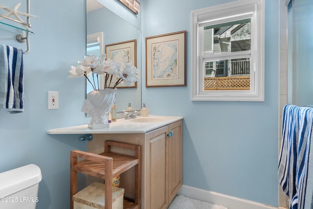 full bathroom featuring baseboards, vanity, and toilet