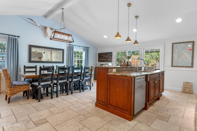 kitchen featuring stone counters, a sink, stainless steel dishwasher, brown cabinetry, and stone tile flooring