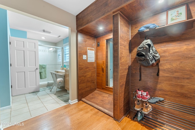 bathroom featuring tile patterned flooring, baseboards, and tiled shower