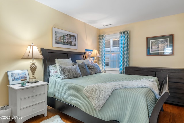 bedroom featuring wood finished floors and visible vents