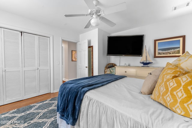 bedroom featuring a closet, visible vents, ceiling fan, wood finished floors, and baseboards