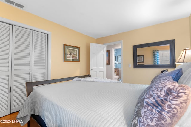 bedroom featuring visible vents, a closet, and wood finished floors