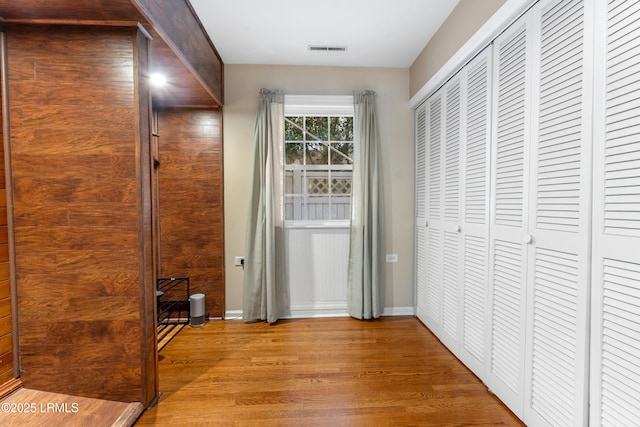 interior space with baseboards, visible vents, and wood finished floors