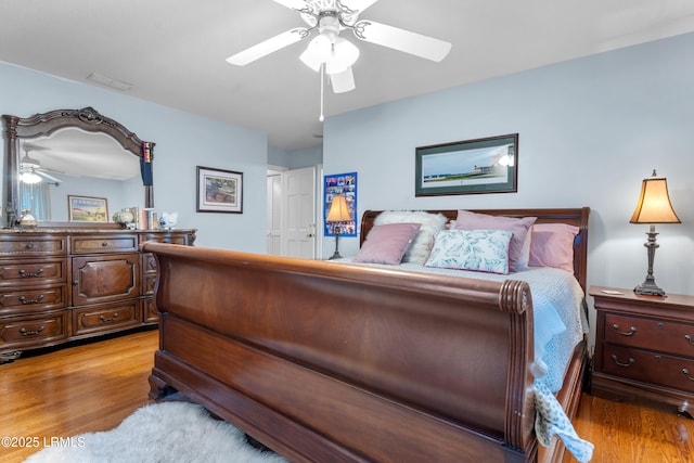 bedroom featuring light wood-type flooring, visible vents, and a ceiling fan