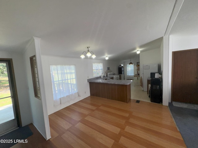 36 Clear Spring Rd, Saint Helena Island, SC 29920 - kitchen with a peninsula, light wood-style flooring, a chandelier, open floor plan, and plenty of natural light