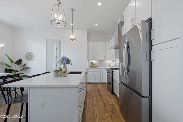 420 Waight St, Beaufort, SC 29902 - kitchen with stainless steel appliances, an island with sink, white cabinetry, a breakfast bar, and decorative backsplash