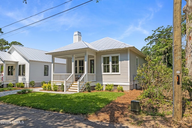 420 Waight St, Beaufort, SC 29902 - view of front of house with a porch, a chimney, a metal roof, and a front lawn