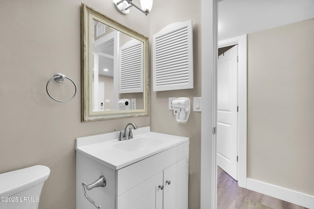 bathroom featuring vanity, hardwood / wood-style flooring, and toilet