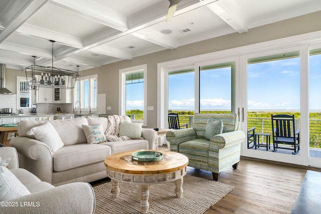 living area with light wood-style flooring, coffered ceiling, and beam ceiling