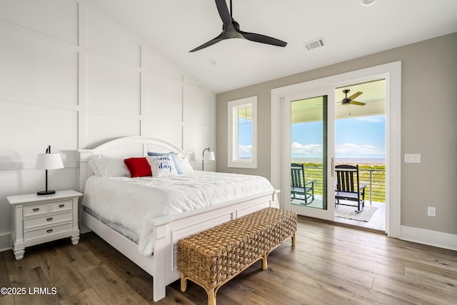 bedroom with access to exterior, multiple windows, wood finished floors, lofted ceiling, and a ceiling fan