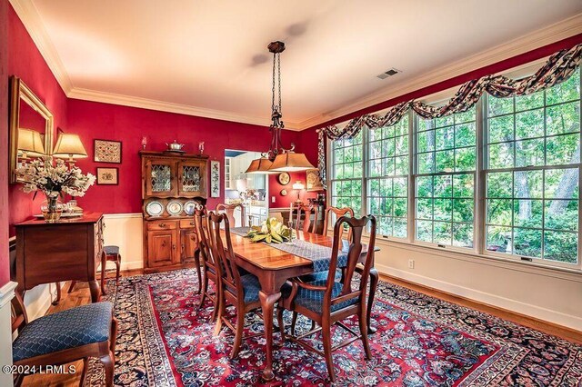 dining space with ornamental molding and hardwood / wood-style floors