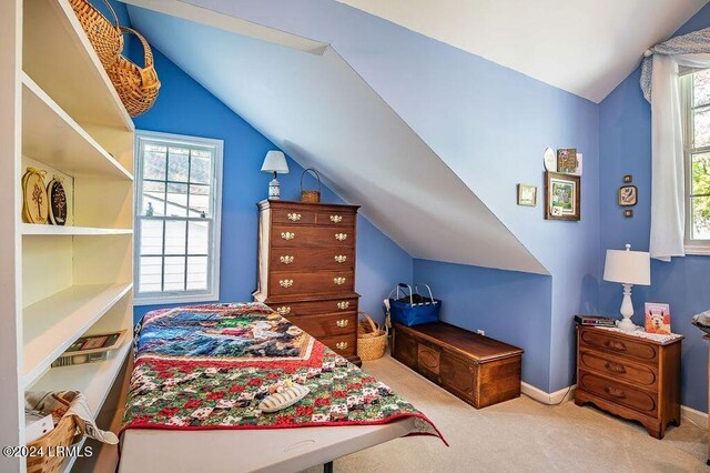 bedroom featuring light colored carpet and lofted ceiling