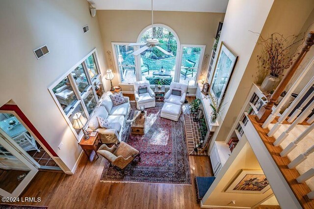 living room with a towering ceiling and hardwood / wood-style flooring