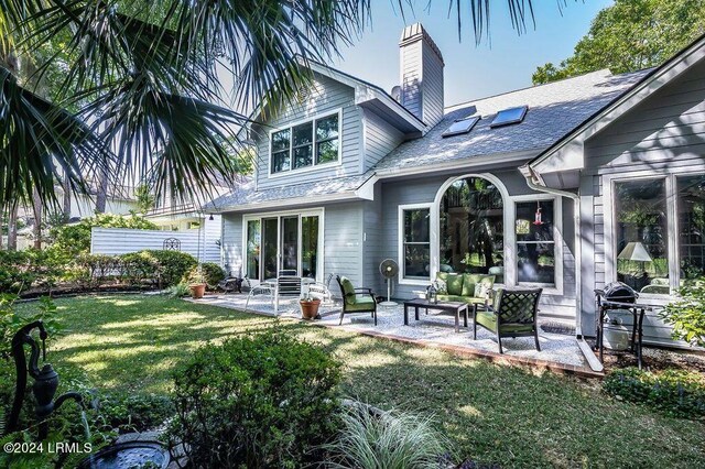 rear view of property with a yard, outdoor lounge area, and a patio