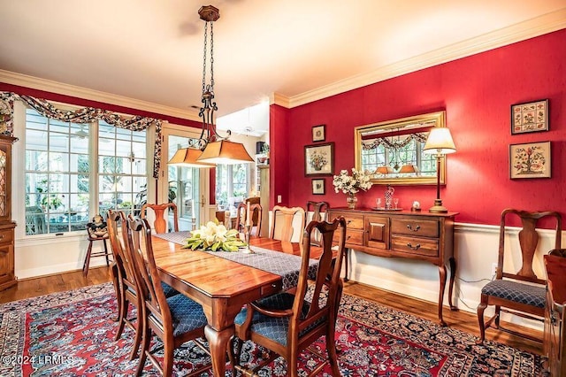 dining area with wood-type flooring and ornamental molding