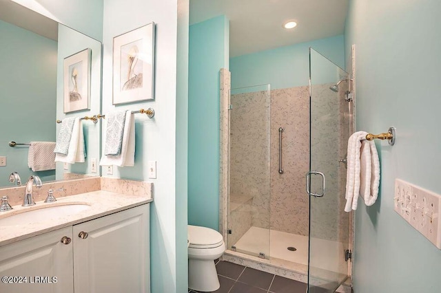 bathroom featuring tile patterned flooring, vanity, toilet, and a shower with shower door