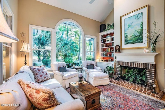 interior space with ceiling fan, a fireplace, and high vaulted ceiling