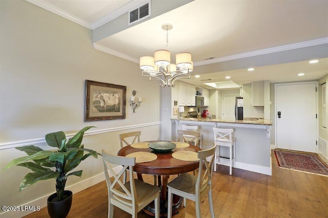 13 Harbourside Ln Unit 7155, Hilton Head Island, SC 29928 - dining space with a chandelier, wood finished floors, crown molding, and recessed lighting