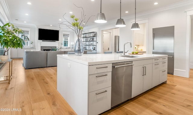 kitchen featuring white cabinetry, pendant lighting, sink, and a center island with sink