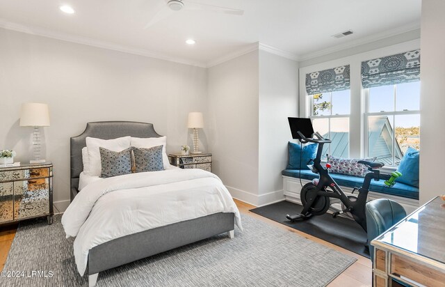 bedroom featuring crown molding, wood-type flooring, and ceiling fan