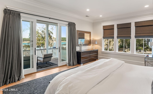 bedroom with a water view, ornamental molding, hardwood / wood-style floors, and access to outside