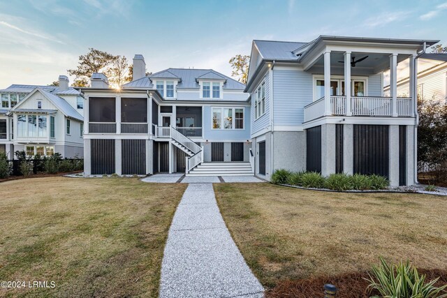 view of front of home with a front yard, a sunroom, and ceiling fan