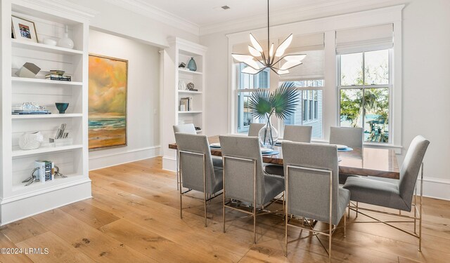 dining area featuring built in features, plenty of natural light, a chandelier, and light hardwood / wood-style flooring