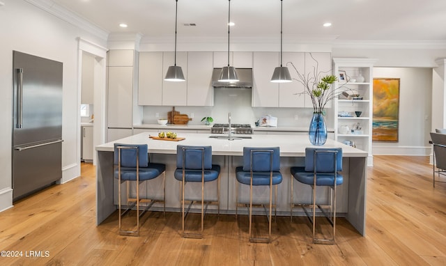 kitchen with pendant lighting, a kitchen bar, and stainless steel built in fridge