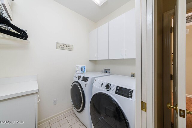 laundry area with independent washer and dryer, light tile patterned floors, and cabinets