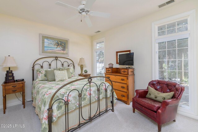 carpeted bedroom featuring multiple windows and ceiling fan