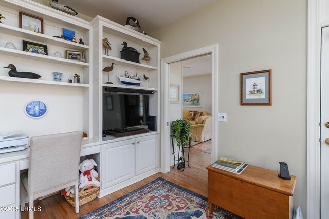 home office with light hardwood / wood-style flooring