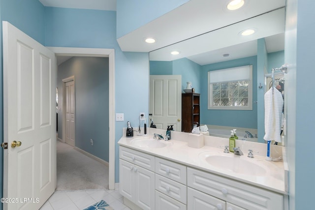 bathroom with tile patterned flooring, vanity, and a tub