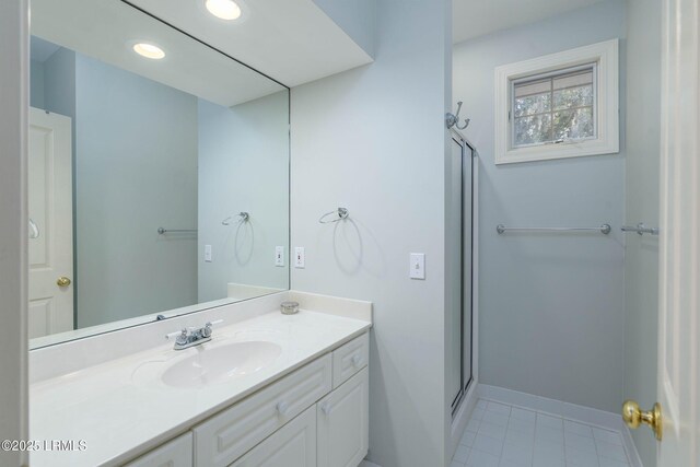 bathroom featuring a shower with door and vanity