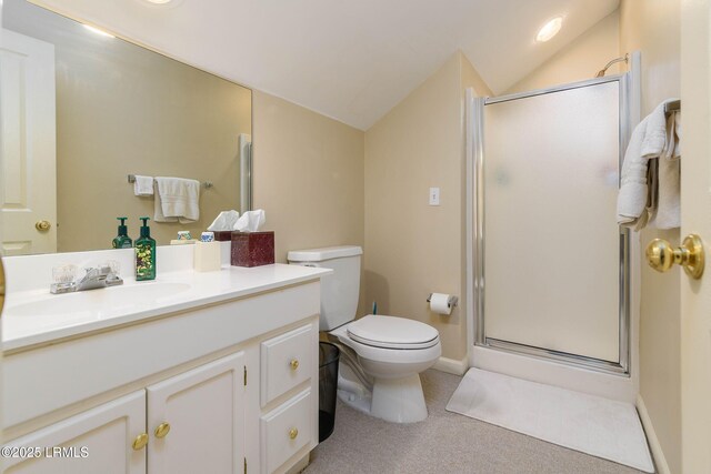 bathroom featuring lofted ceiling, vanity, a shower with shower door, and toilet