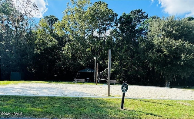 view of property's community featuring a lawn and volleyball court