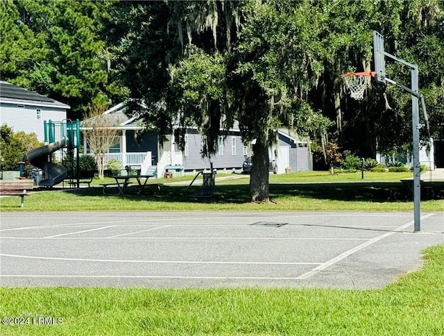 view of sport court with a lawn and a playground