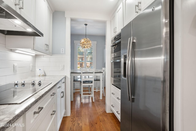 kitchen with white cabinetry, stainless steel appliances, decorative light fixtures, and light stone counters