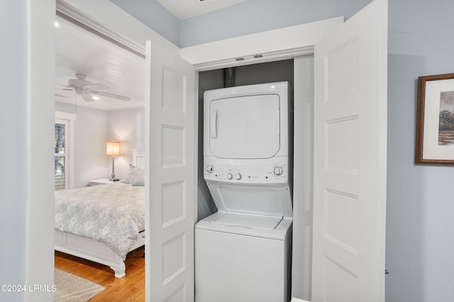 laundry area with wood-type flooring, ceiling fan, and stacked washing maching and dryer