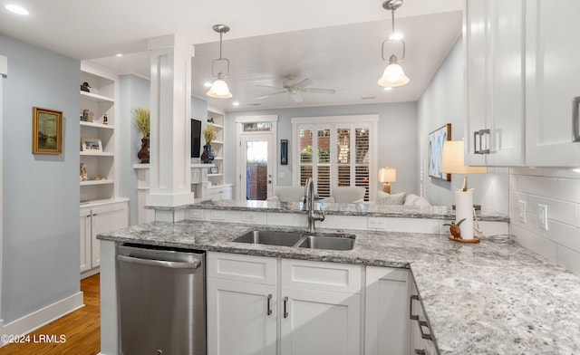 kitchen with pendant lighting, sink, white cabinets, and dishwasher