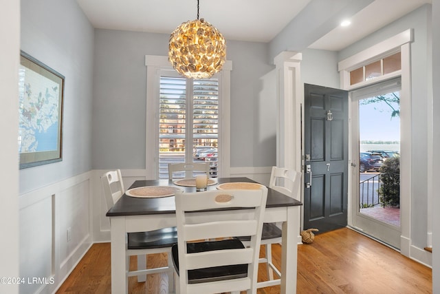 dining space with a wealth of natural light, a chandelier, and light hardwood / wood-style flooring