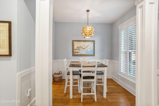 dining area with hardwood / wood-style flooring and a notable chandelier