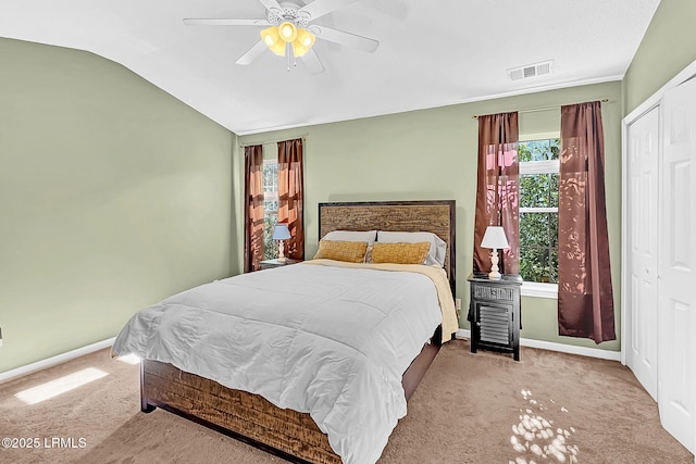 carpeted bedroom with vaulted ceiling, a closet, and ceiling fan