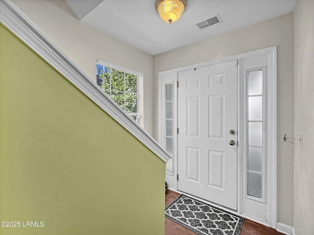 entryway featuring dark hardwood / wood-style flooring and a textured ceiling