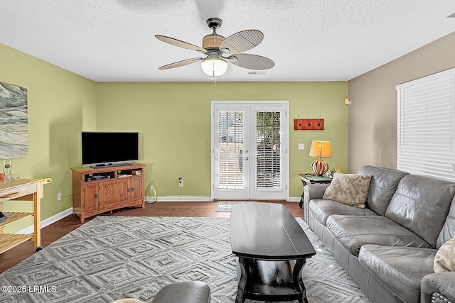 living room featuring light hardwood / wood-style flooring, a textured ceiling, ceiling fan, and french doors