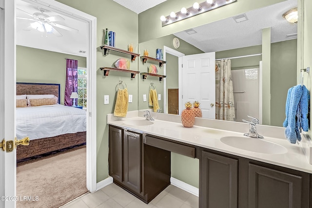 bathroom featuring a textured ceiling, vanity, curtained shower, ceiling fan, and tile patterned flooring