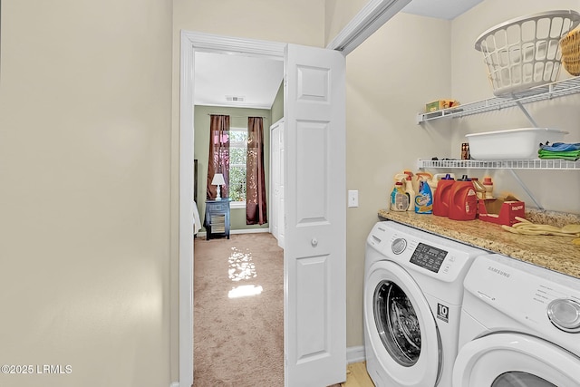 clothes washing area featuring separate washer and dryer and light carpet